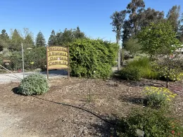 Entrance to the three sisters garden, with a sign saying, "Welcome, come on in"