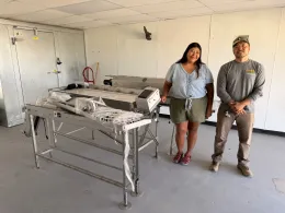 Two clients standing in a room near a walk in cooler.