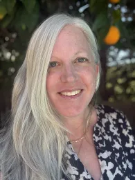 A headshot of Karen Galbraith with an orange tree in the background.