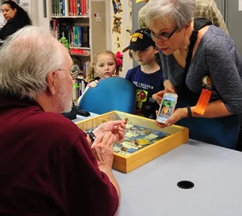 UC Master Gardener Tece Markel of Newcastle shows a photo of a male Valley carpenter bee to Robbin Thorp, distinguished emeritus professor of entomology, who is holding a live bee. With her are grandchildren Fiona, 5 and Declan McManus, 7, of Rocklin.
