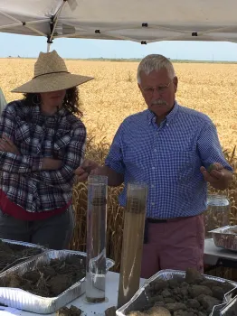 UC Cropping Systems Specialist, Jeff Mitchell, and UC Farm Advisor, Sarah Light, demonstrate improved soil aggregate stability (left cylinder) in no-till versus conventional tillage trials.