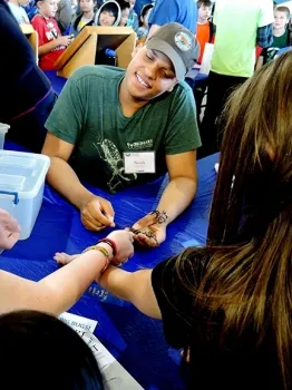 Noah Crockette encouraging youngsters at the Solano Ag Day, Vallejo, to get acquainted with insects at the Bohart Museum of Entomology. (Photo by Kathy Keatley Garvey)