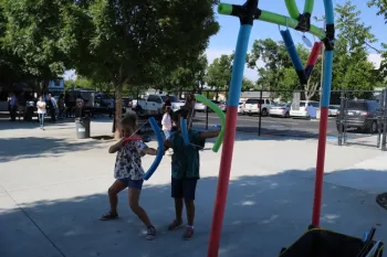 Students shooting pool noodle arrows at target