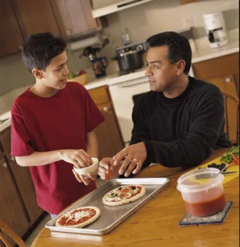 A father and son make pizzas
