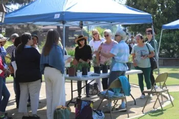 group of people in a garden listening to gardening information