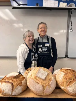 Volunteers leading a sourdough workshop with bread samples on the table
