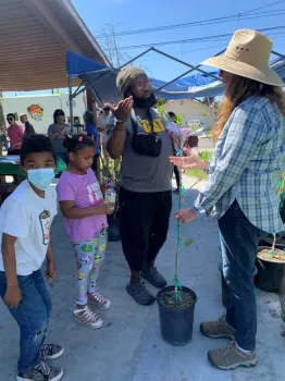 master gardeners explaining tree attributes to a person who will be planting the tree at home.