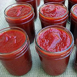 Jars of red tomato sauce without lids. 