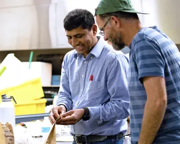 Smiling ANR crop advisor engaging in conversation with a visitor