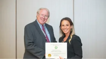 Michael Rethwisch, left, receives a certificate from a woman