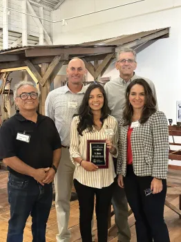 Johanna holds her plaque and poses with 4 people
