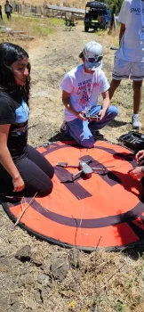 4-H Youth leader assisting another youth at the landing pad