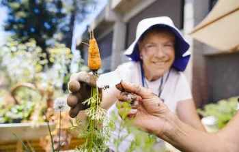 Image of gardeners holding a carrot.