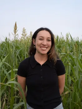 Li is standing in a field of plants that are nearly as tall as she is