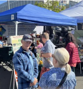 Ask A Master Gardener volunteer Bob Archer listens to a gardener's question at a local Famers Market.