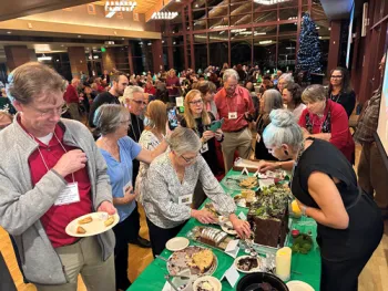 UC Master Gardeners, family members and other guests gather around the dessert table and May Coleman's gorgeous cake.