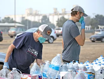 Volunteers handing out bottled water to community members in need.