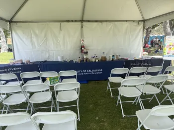 UC Cooperative Extension water filtration booth setup with demonstration materials and seating for students.