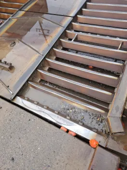 Outdoor metal wash station with a small red tomato near the bottom