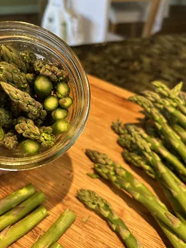raw asparagus stuffed into a jar with flat end down
