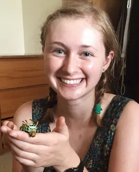 UC Davis doctoral candidate Grace Horne holding a hickory horned devil caterpillar (Citheronia regalis).