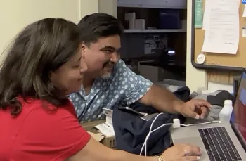 Dos personas observan una computadora