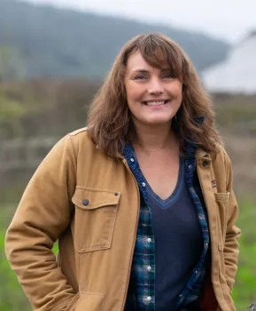 Photo of Ombudsperson Kerry McGrath standing in a field