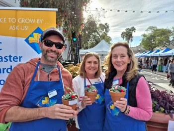 Group of three master gardeners holding potted succulents