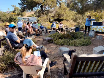 Group of people sitting in a garden in a master gardener event