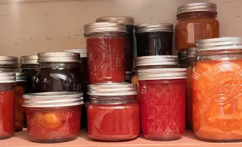 Jars of jams, jellies, and chutneys in a well-stocked pantry. J.C. Lawrence