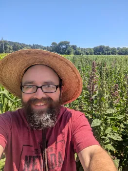Jared Zystro smiles in a selfie in a field of quinoa