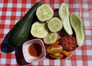 zucchini, lemon cucumbers, and tomatoes cut in half to display seeds