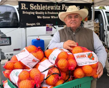 Tulare farmer with Navel Oranges at Farmers Market - Courtesy Liz Rottger