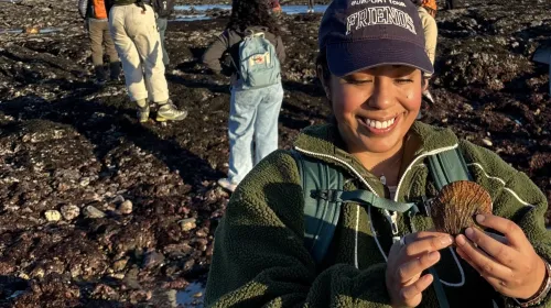 Daisy Prado holds a shell as she explores Duxbury Reef as part of a UC California Naturalist course excursion