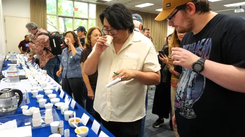 Two Kearney REC Tea Day attendees put their noses into cups to evaluate the aroma of various teas