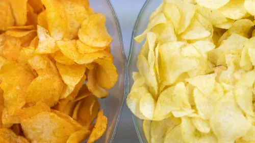Two bowls of chips, one orange tinged and one plain yellow
