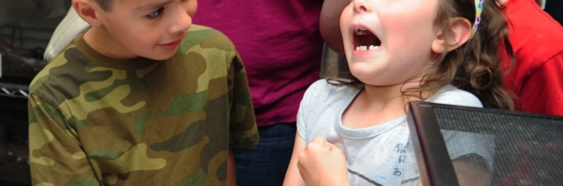 Roxanne Bell, 7, of Davis, decided that Peaches, the rose-haired tarantula, "tickles!" Watching her reaction at the Bohart Museum of Entomology, during "Take Your Daughers (And Sons) to Work" Day is Joel Fuerte, 6, of Woodland. Their mothers work at UC Davis. (Photo by Kathy Keatley Garvey)