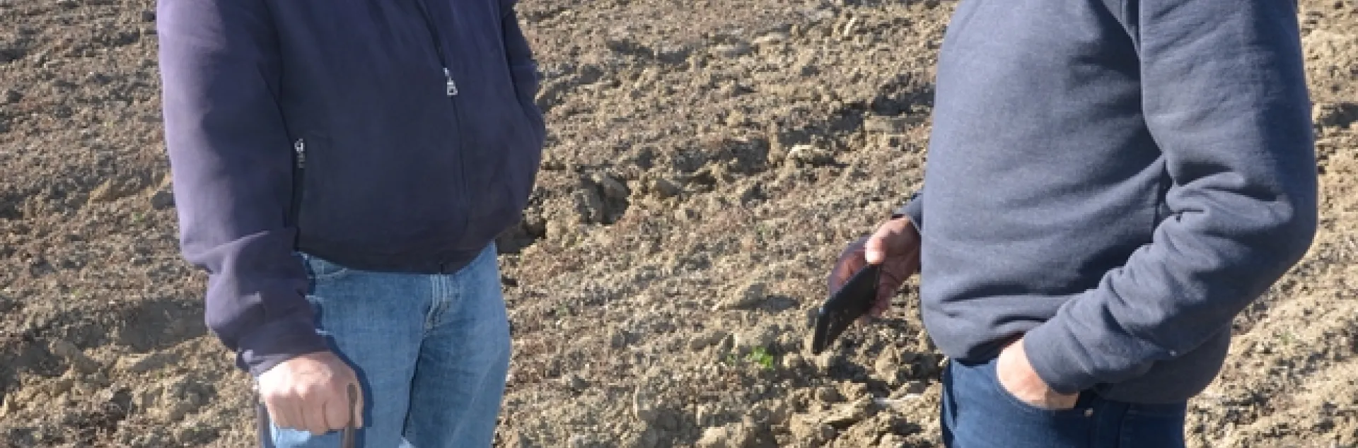 Jesse Sanchez and Roberto Botelho (left and right) examine soil at Sano Farms cover crop fields in Firebaugh, CA, February 23, 2018