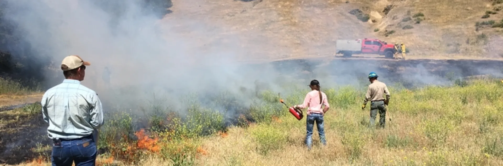 Workshop participant learning how to use a drip torch.