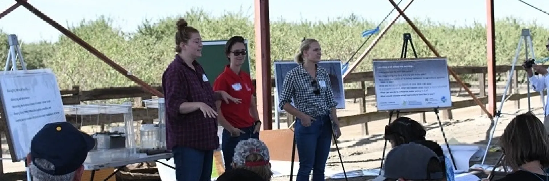Emily Lovell (left), Shulamit Shroder (center), and Caddie Bergren (right) sharing with field educational event participants information about the CDFA Healthy Soils and State Water Efficiency Enhancement Programs