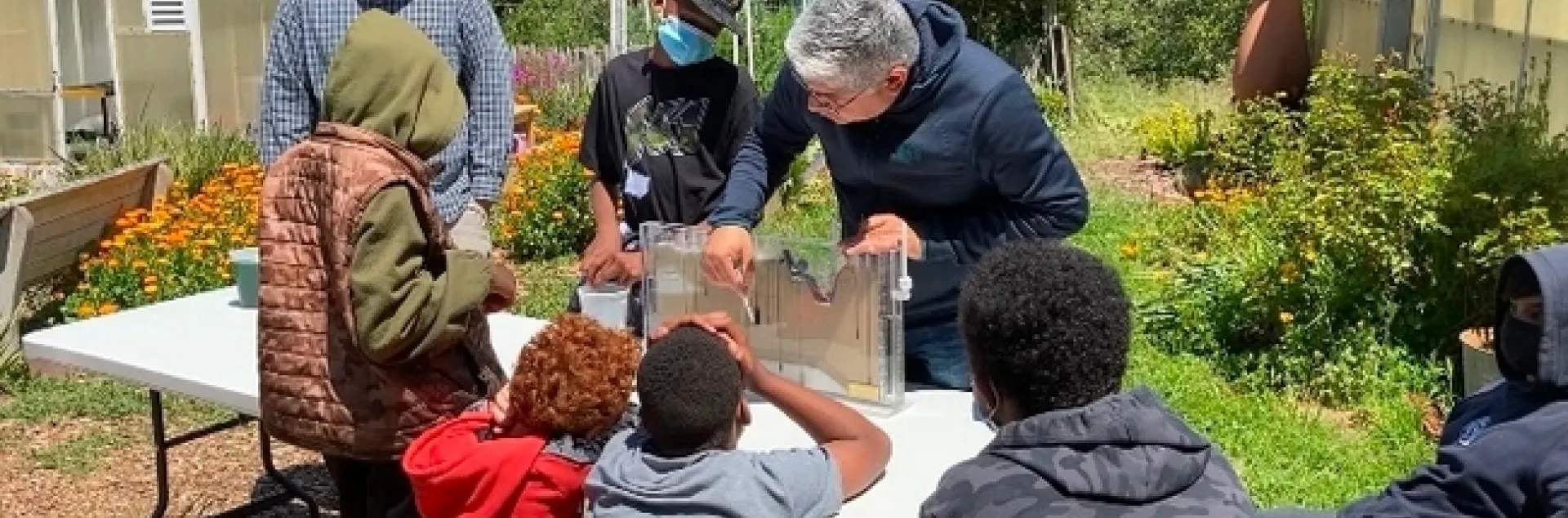 Sam Sandoval Solis, especialista de la Extensión Cooperativa de la UC, demuestra a un grupo de estudiantes cómo el agua superficial fluye hacia el agua subterránea.