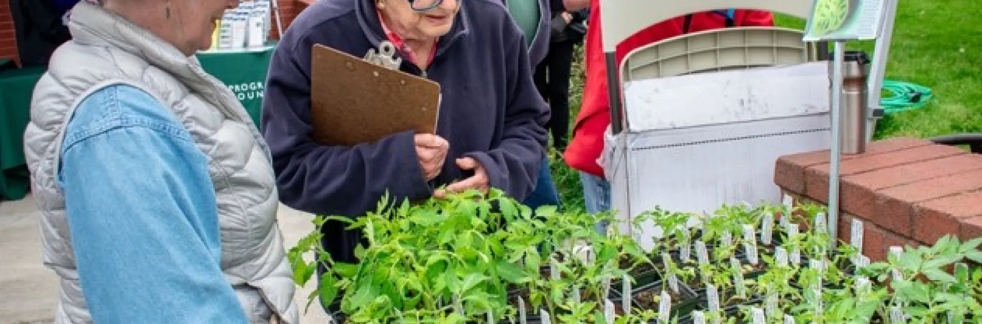 UC Master Gardeners Mary Jo Corby and Barbara Siegel check plants before a past GTPS while other CoCoMGs set up. Photo by Fletcher Oakes.