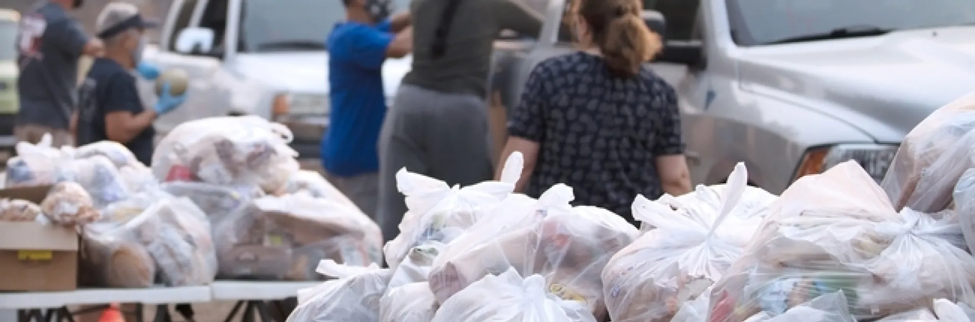 Durante las inundaciones, incendios forestales y otros desastres, la gente necesita comer. Las organizaciones comunitarias colaboran con la North Coast Emergency Food System Partnership para fortalecer los sistemas locales y regionales y crear una resiliencia comunitaria. Evacuados de un incendio en el 2020 reciben canastas de alimentos. Fotografía por Evett Kilmartin