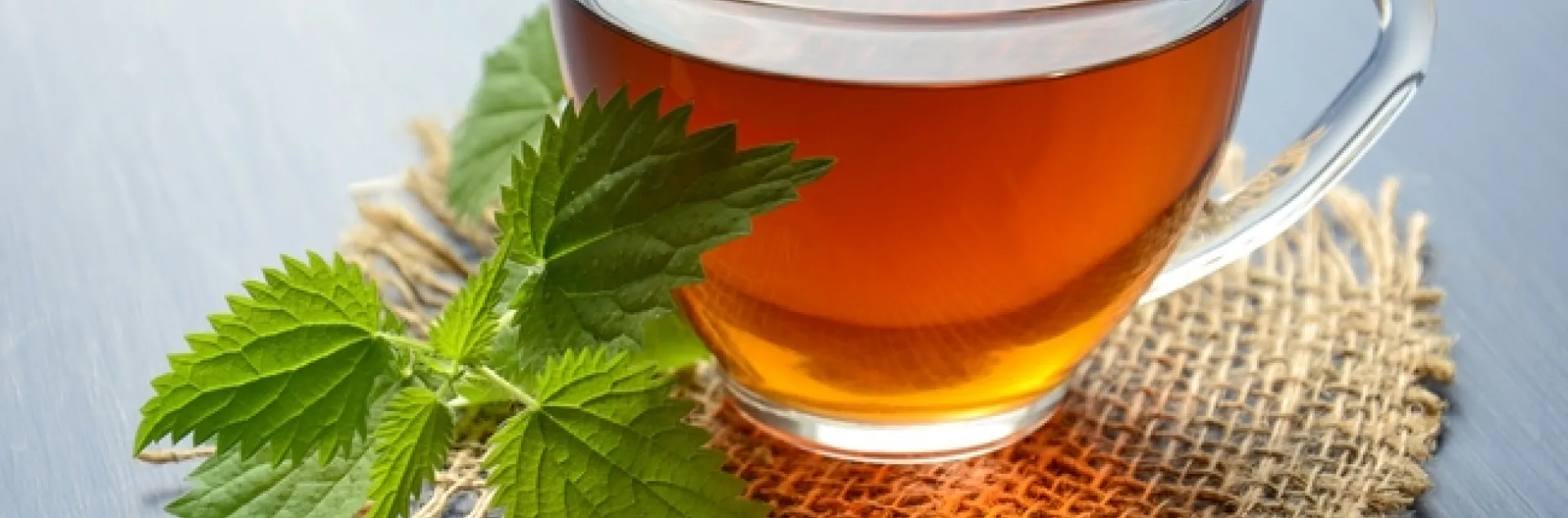 A cup of herb tea on a burlap coaster.