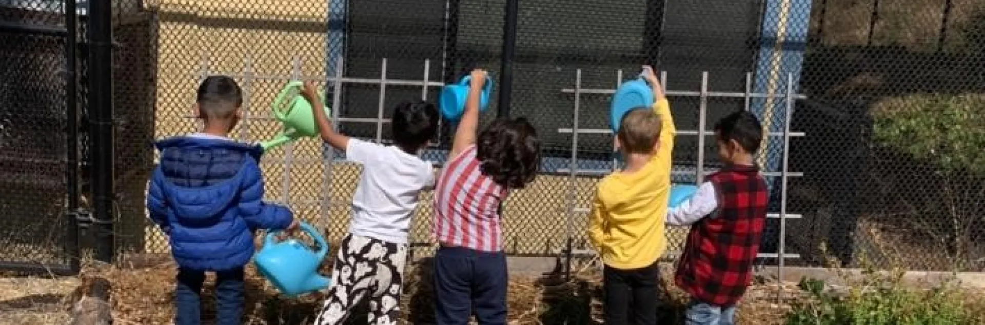 Fairmont Elementary students work in the garden under the watchful eye of their teacher.