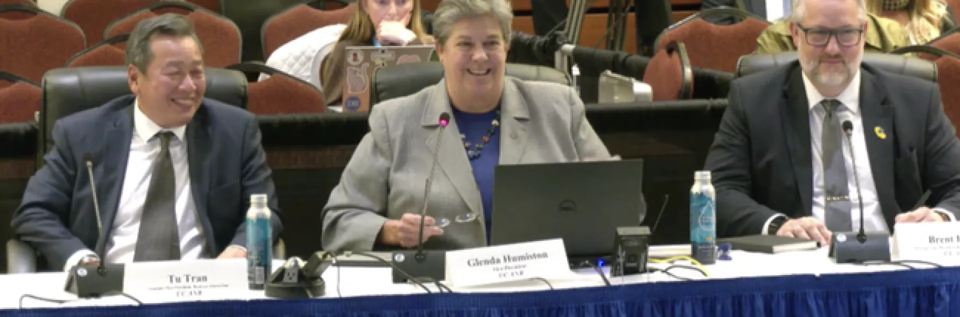 From left, Tu Tran, Glenda Humiston and Brent Hales are sitting at a long table and smiling.