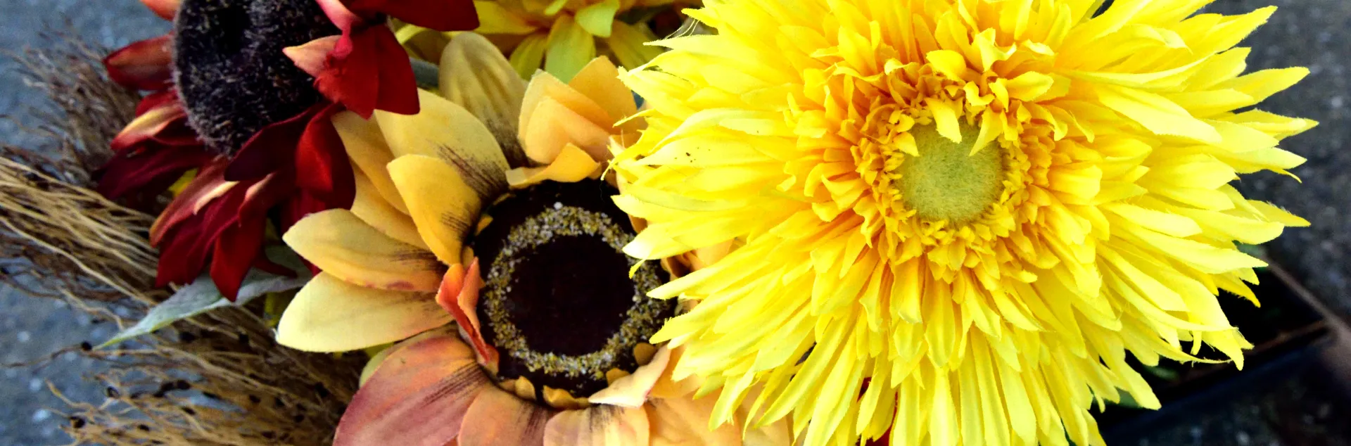 Bouquet of sunflowers in yellow, red, and peach tones, including a fluffy double-petaled yellow variety.