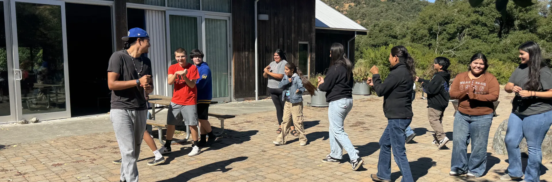 Tribal youth participate in a traditional hand game