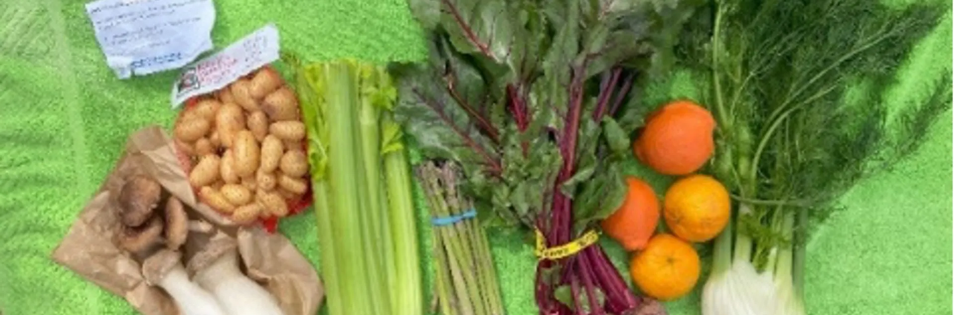 A collection of fresh produce laid out on a green towel.