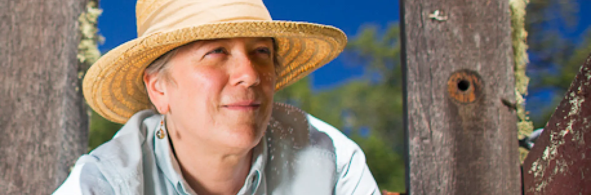 Headshot of Cynthia wearing a wide brim hat